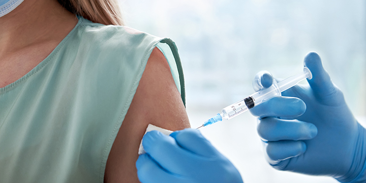 Young woman receiving a vaccination jab 